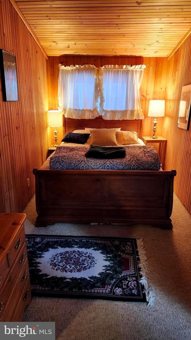 carpeted bedroom with wooden walls and wooden ceiling