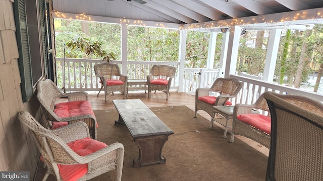 sunroom featuring vaulted ceiling with beams and ceiling fan