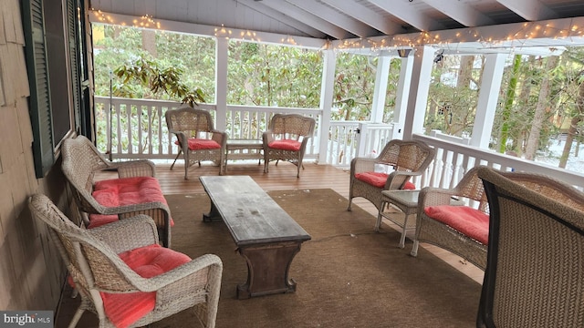 sunroom / solarium featuring vaulted ceiling with beams and a healthy amount of sunlight