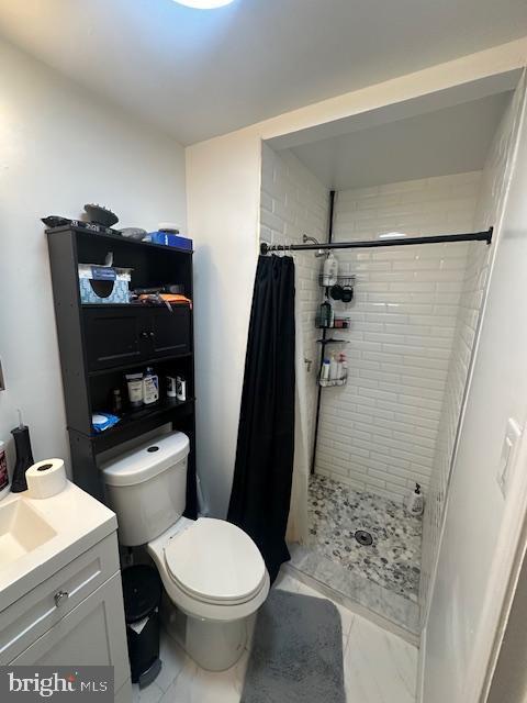 bathroom with toilet, vanity, and walk in shower