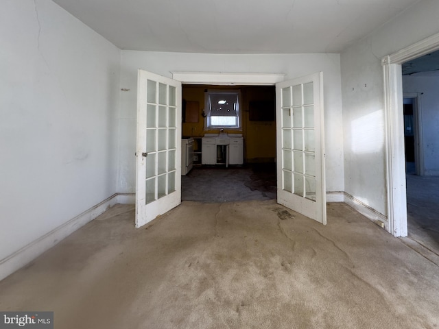 carpeted empty room with sink and french doors