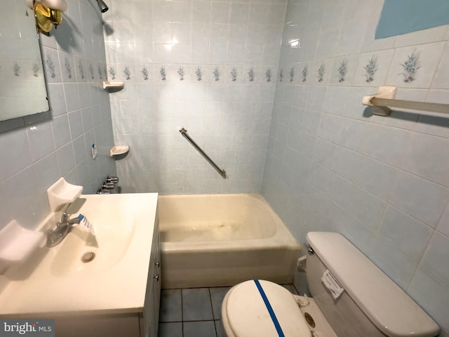 full bathroom with tile patterned floors, vanity, toilet, and tile walls