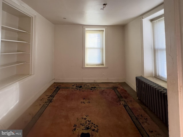 unfurnished room with built in features and radiator