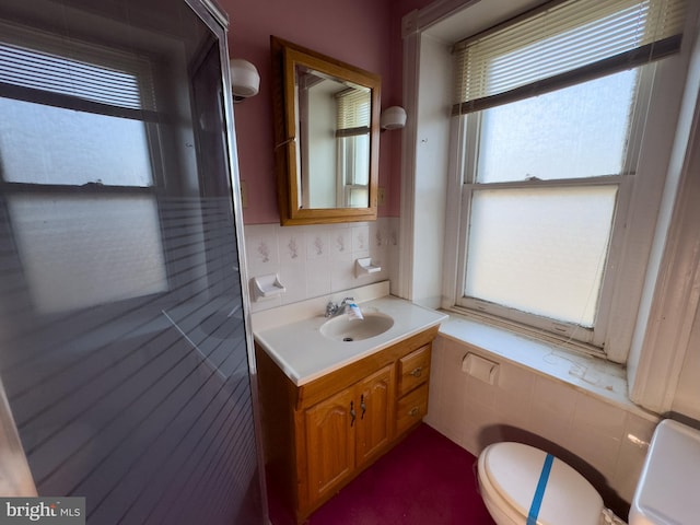 bathroom with tasteful backsplash, vanity, and toilet