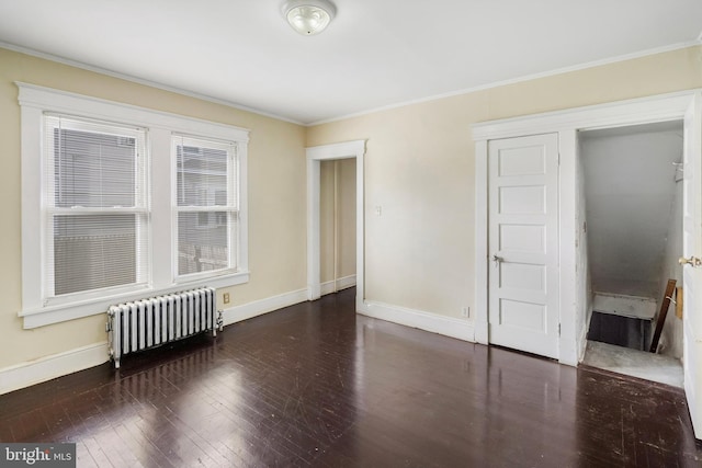 unfurnished room featuring dark hardwood / wood-style flooring, radiator, and crown molding