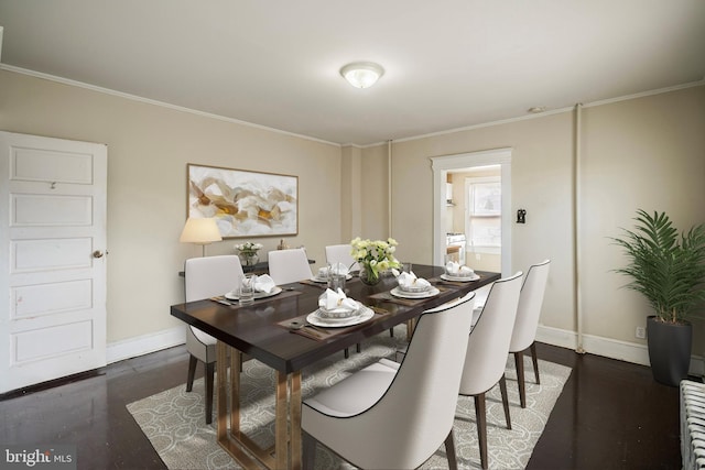 dining space with crown molding and dark hardwood / wood-style flooring