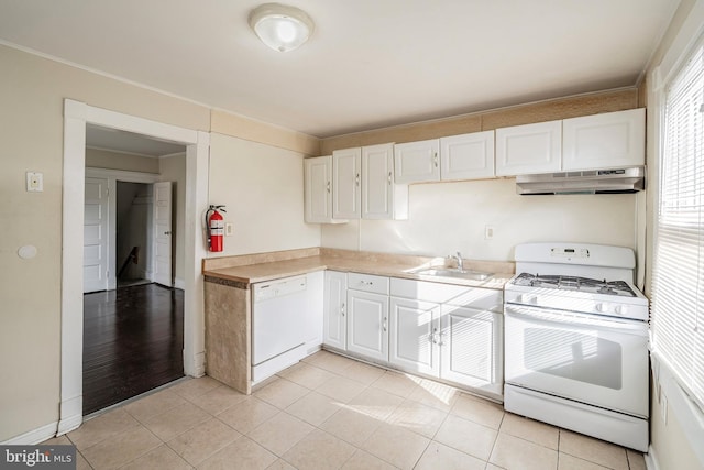 kitchen with white appliances, light tile patterned floors, sink, and white cabinets