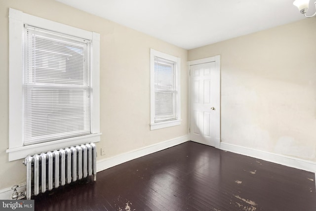 unfurnished room featuring radiator and dark wood-type flooring