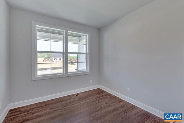 unfurnished room with dark hardwood / wood-style flooring