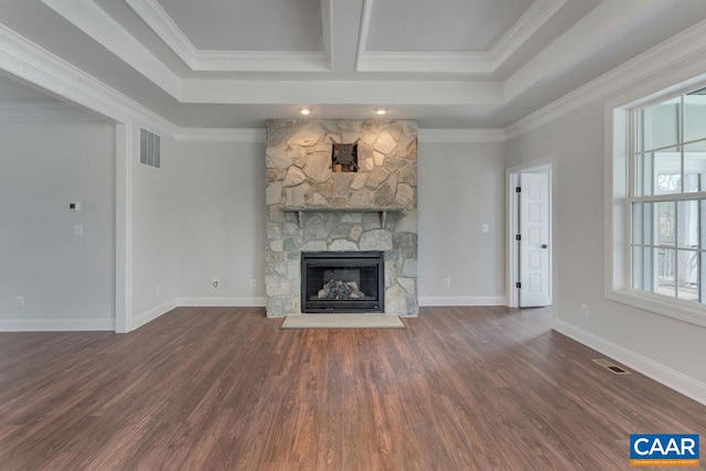 unfurnished living room featuring dark hardwood / wood-style flooring, a stone fireplace, and ornamental molding