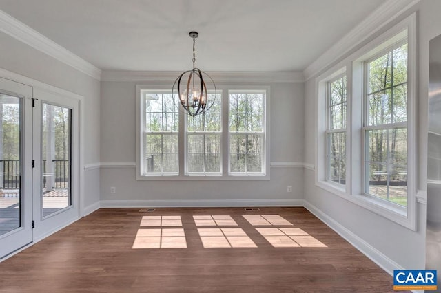 unfurnished dining area featuring a chandelier, dark wood-type flooring, and ornamental molding