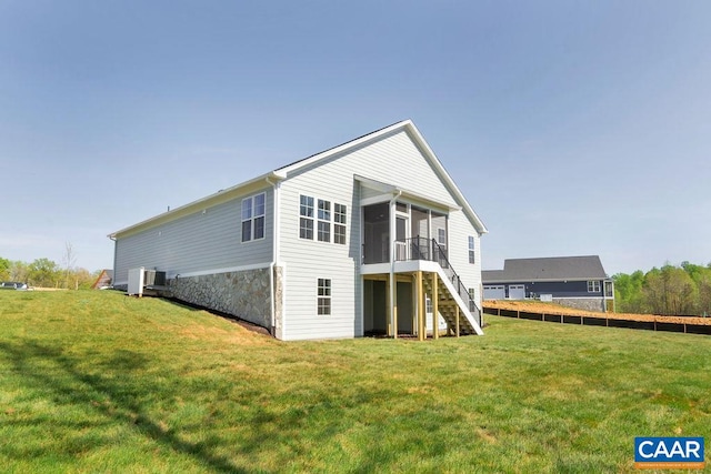 rear view of property with a sunroom and a yard