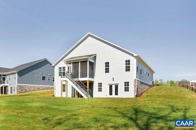 back of house featuring french doors, a lawn, and a sunroom