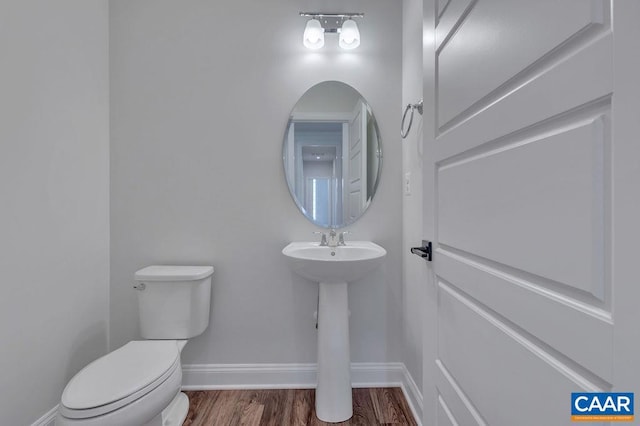 bathroom with hardwood / wood-style floors and toilet