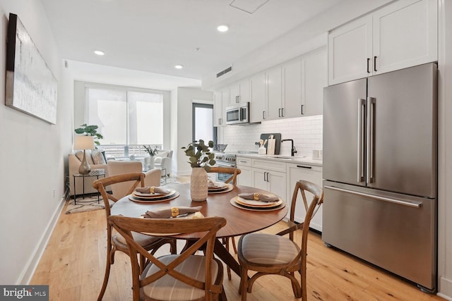 dining area featuring sink and light wood-type flooring