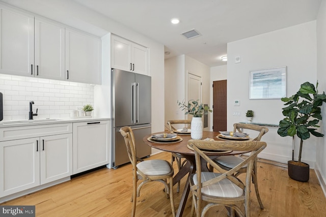 dining area with light hardwood / wood-style floors and sink