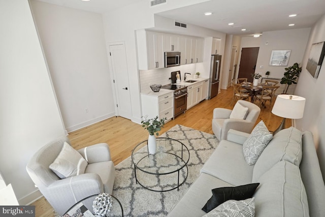 living room featuring light hardwood / wood-style floors and sink