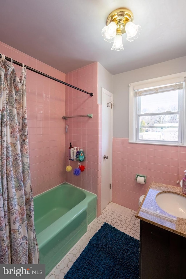 bathroom with tile patterned floors, vanity, shower / bath combo, and tile walls