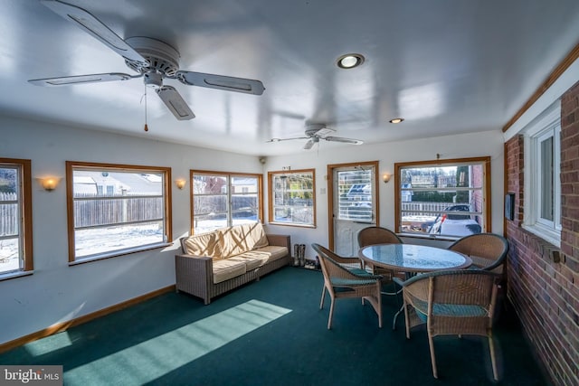 sunroom / solarium with a wealth of natural light and ceiling fan