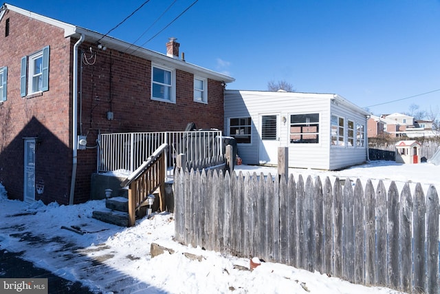 view of snow covered back of property