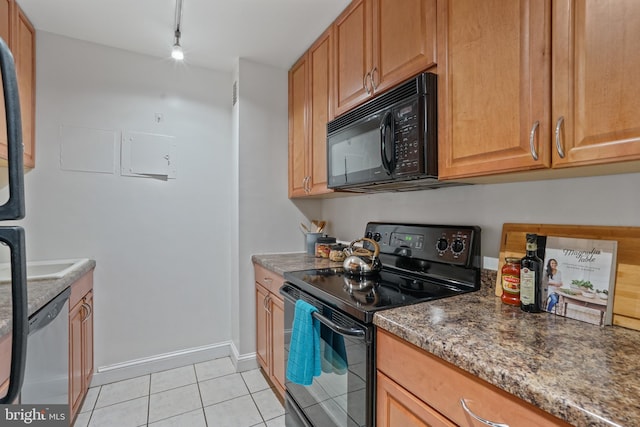 kitchen featuring dark stone countertops, light tile patterned floors, black appliances, and rail lighting