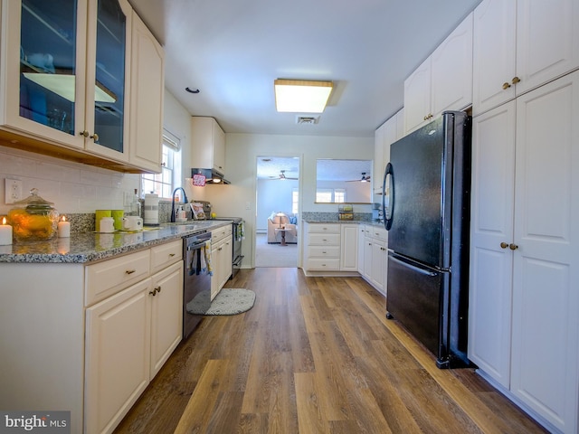 kitchen with black fridge, white cabinetry, hardwood / wood-style floors, and dishwasher