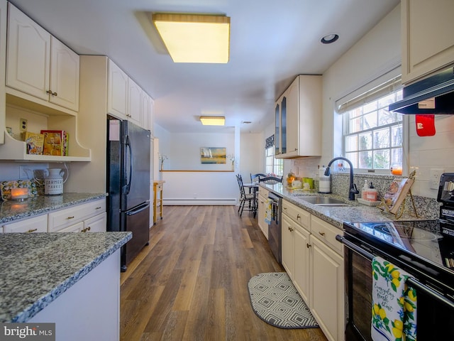 kitchen featuring sink, white cabinets, a baseboard heating unit, black appliances, and dark wood-type flooring