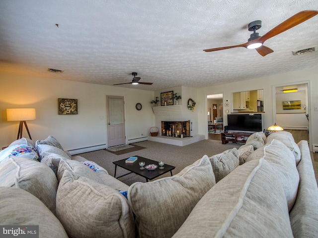 living room with a textured ceiling, ceiling fan, and a baseboard heating unit