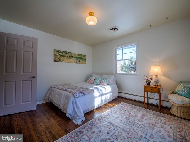 bedroom featuring a baseboard heating unit and dark hardwood / wood-style floors