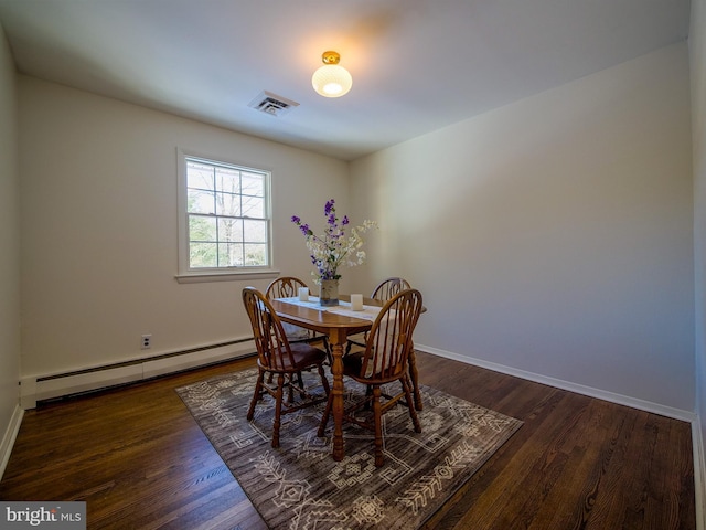 dining space featuring a baseboard heating unit and dark wood-type flooring