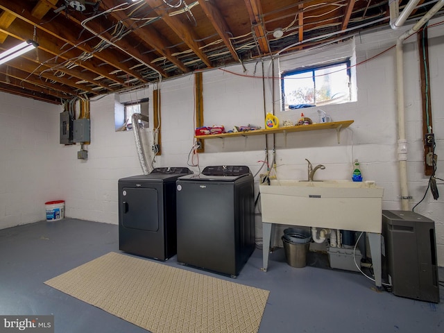 clothes washing area featuring electric panel, washing machine and dryer, and sink