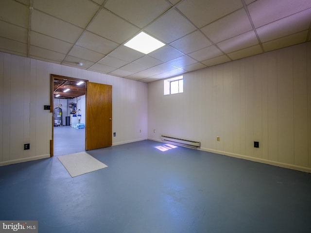 basement with wooden walls and a baseboard radiator