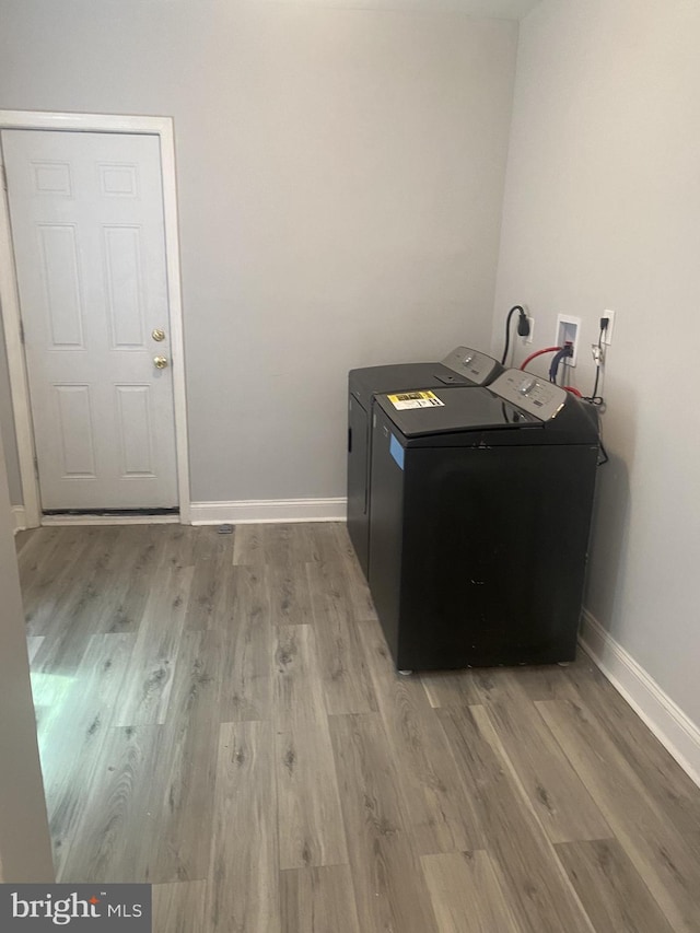 clothes washing area featuring washer and dryer and light hardwood / wood-style floors