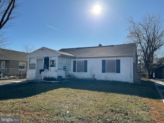 view of front of property with a sunroom and a front yard