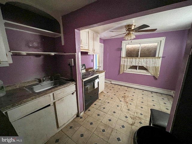 kitchen with ceiling fan, sink, a baseboard radiator, black / electric stove, and white cabinets