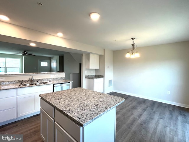 kitchen featuring a kitchen island, pendant lighting, white cabinetry, sink, and stainless steel dishwasher