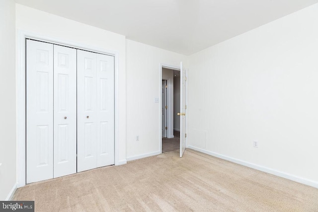 unfurnished bedroom featuring a closet and light carpet