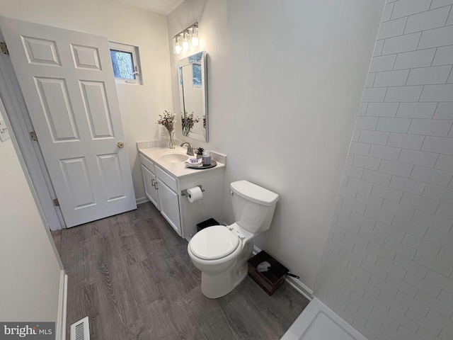 bathroom with vanity, hardwood / wood-style flooring, and toilet