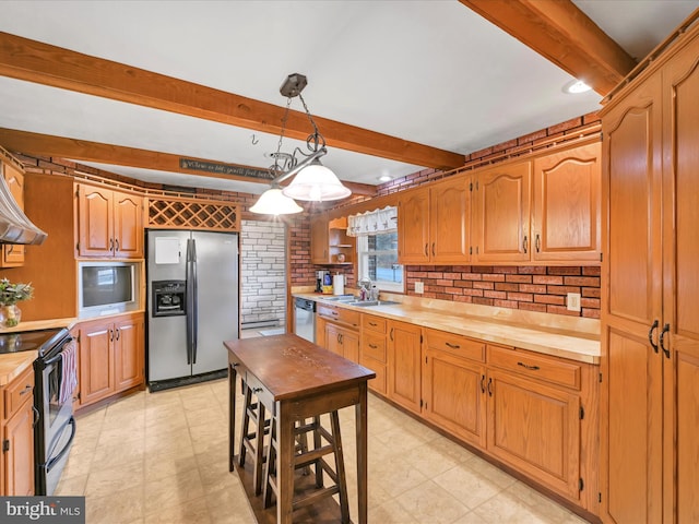 kitchen with pendant lighting, wood counters, sink, appliances with stainless steel finishes, and brick wall