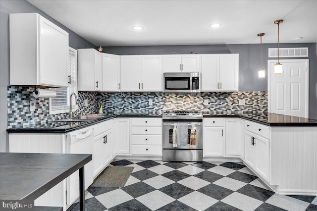 kitchen featuring white cabinets, sink, stainless steel appliances, and hanging light fixtures