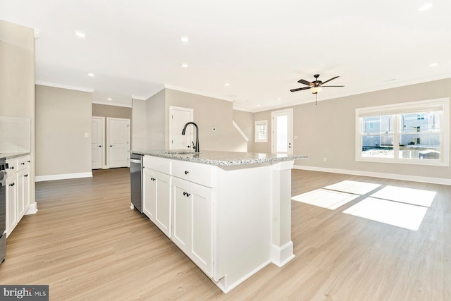 kitchen with sink, a center island with sink, white cabinetry, and light hardwood / wood-style flooring