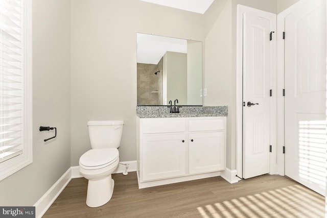 bathroom featuring vanity, hardwood / wood-style flooring, a shower, and toilet