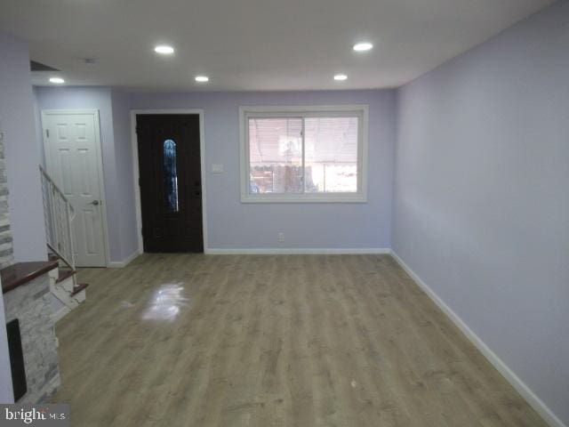 foyer entrance with a fireplace and light hardwood / wood-style flooring