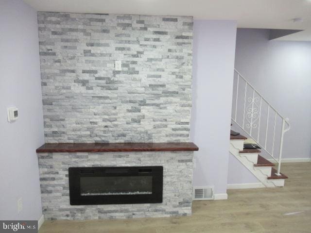 interior space with hardwood / wood-style flooring and a stone fireplace