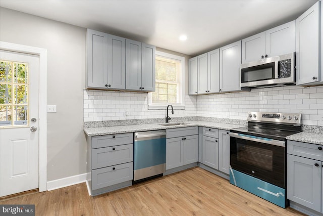 kitchen with gray cabinetry, sink, and stainless steel appliances