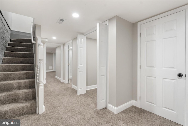 basement featuring light carpet