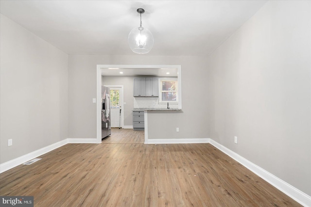 unfurnished living room with light hardwood / wood-style floors and sink