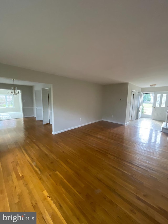 unfurnished room featuring hardwood / wood-style floors and a notable chandelier