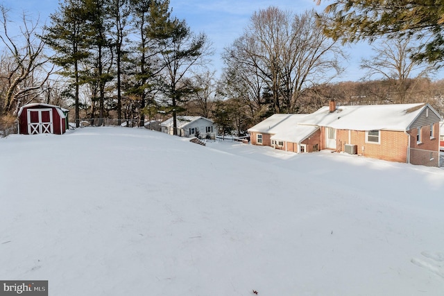 yard layered in snow with a shed