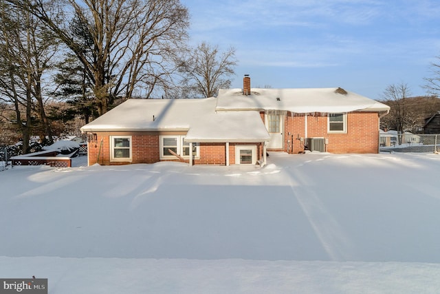 snow covered rear of property with central air condition unit